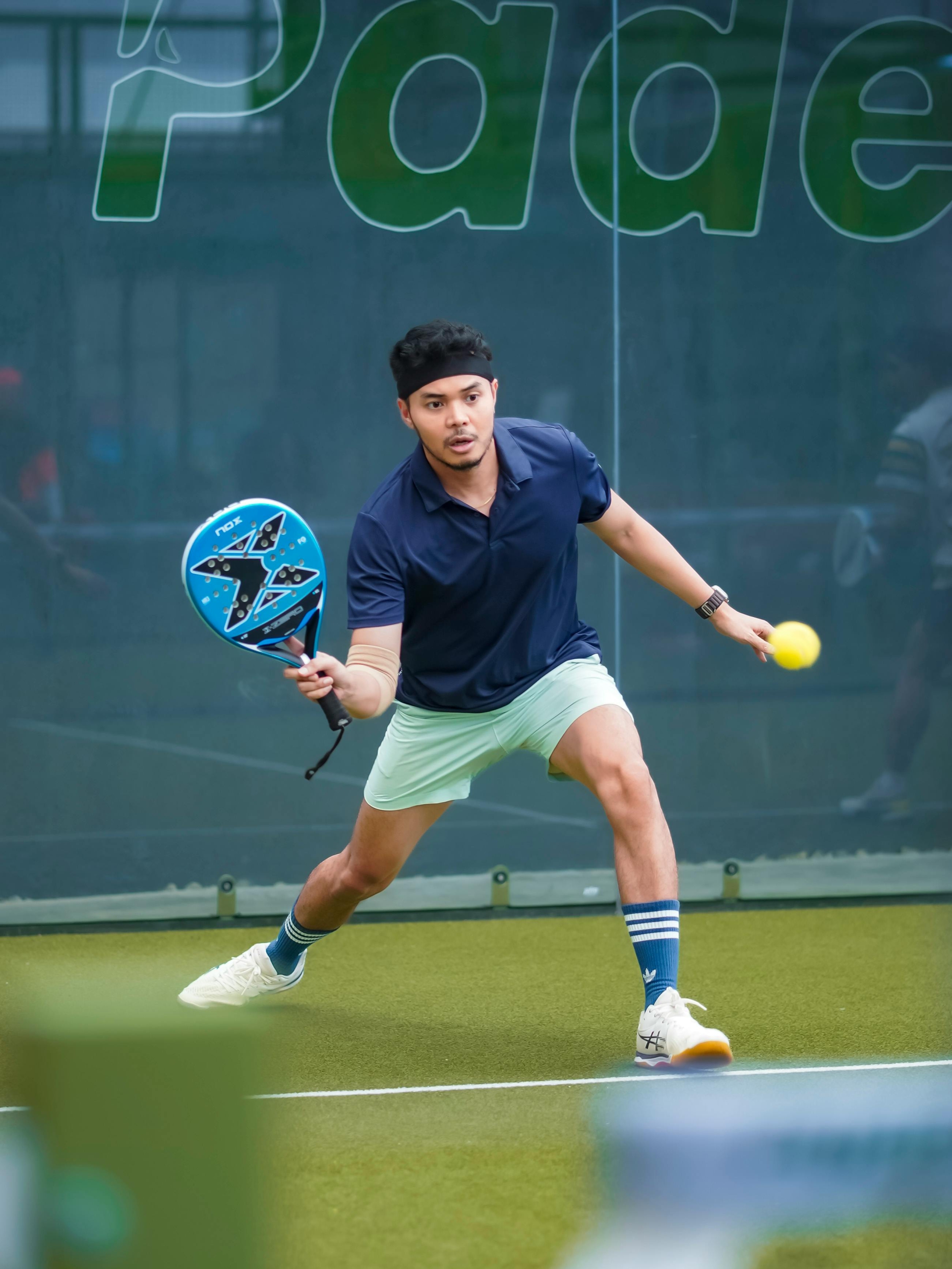 Padel court in the UK with player mid-rally, indoor facility
